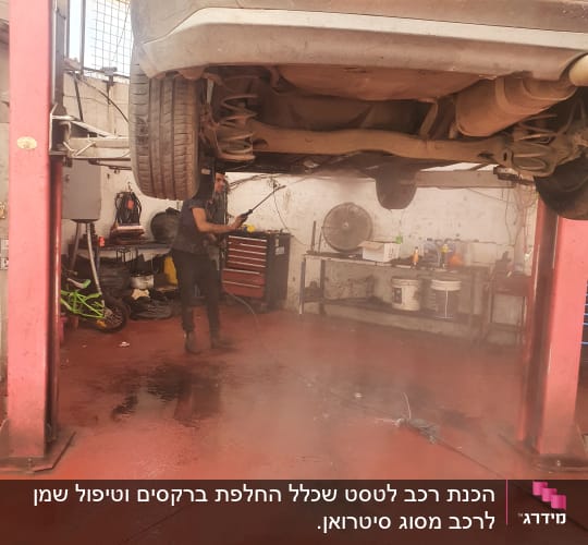 רכב מורם במוסך, עובד עם מכונת שטיפה